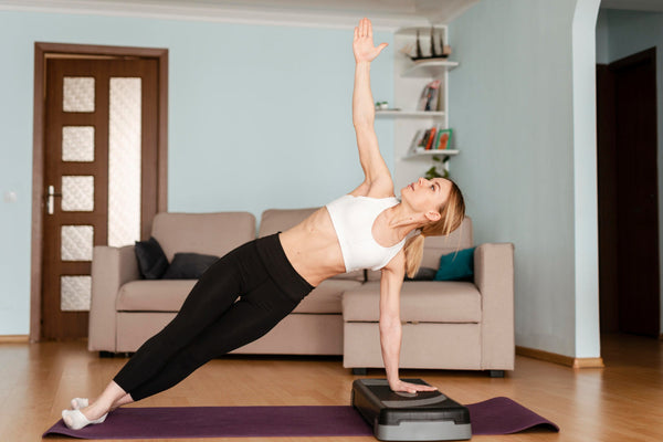 Woman doing sport at home on Vibro PRO vibration plate equipment 